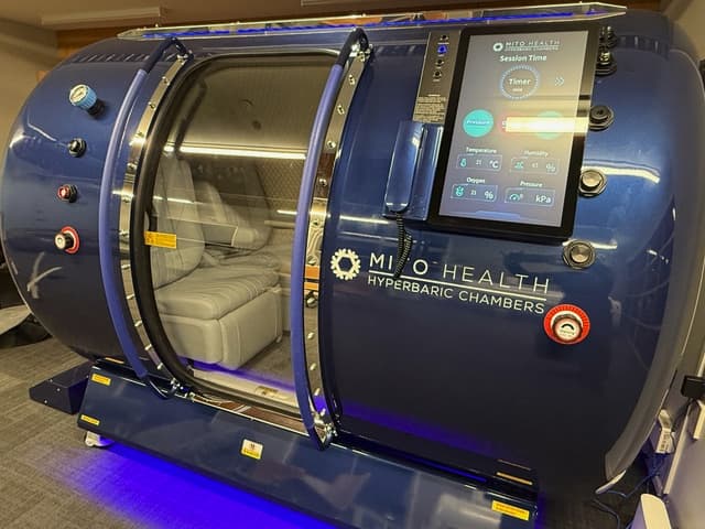 walk-in-hyperbaric-chamber-ext-branded Exterior view of a walk in hyperbaric chamber with door open and a Mito Health logo on the outside