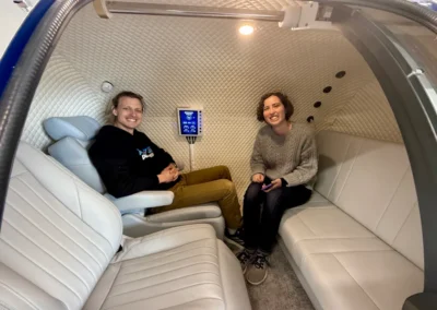Two people seated inside hyperbaric chamber.